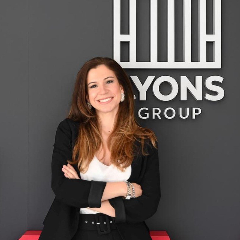 Valentina De Leon in front of the Lyons Group sign